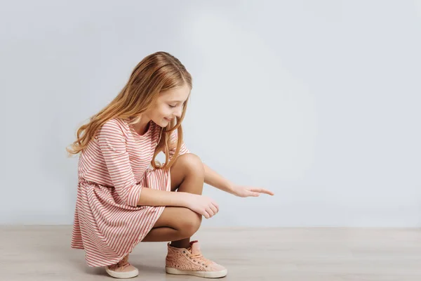 Positiva chica encantada sentado aislado sobre fondo gris —  Fotos de Stock