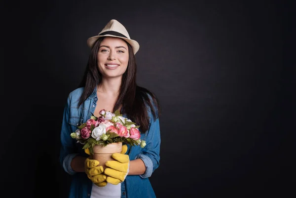 Alegre hembra jardinero holdign maceta de flores — Foto de Stock