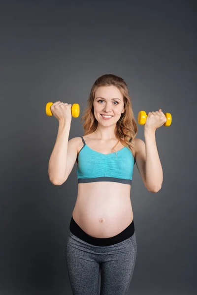 Jolie femme enceinte tenant des haltères — Photo