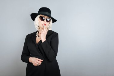 Finger ile dudaklarına dokunmadan üst düzey güzel kadın.