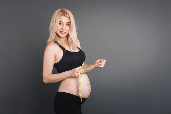 Sorrindo jovem múmia segurando a fita — Fotografia de Stock