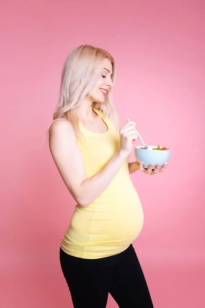 Jeune grossesse regardant une assiette avec salade — Photo