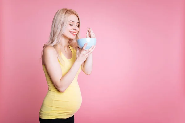 Kobieta w ciąży uśmiechający się jedzenie sałatka — Zdjęcie stockowe