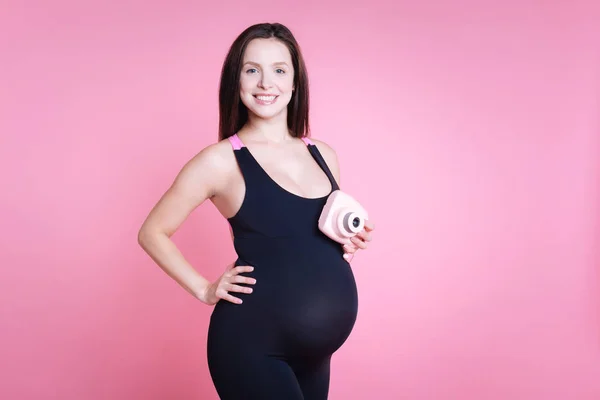 Charmante zwangere vrouw houden van fotocamera — Stockfoto