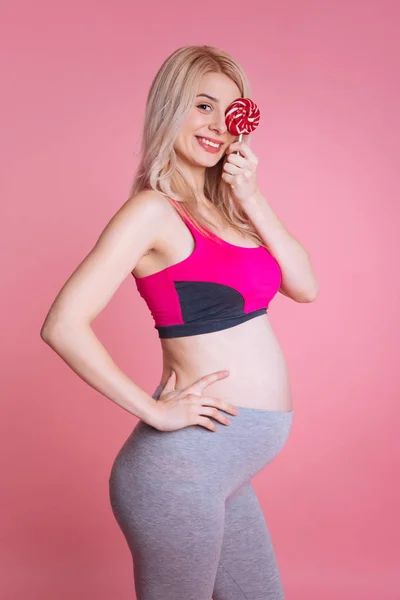 Joyful pregnancy holding a lollipop on the left eye — Stock Photo, Image