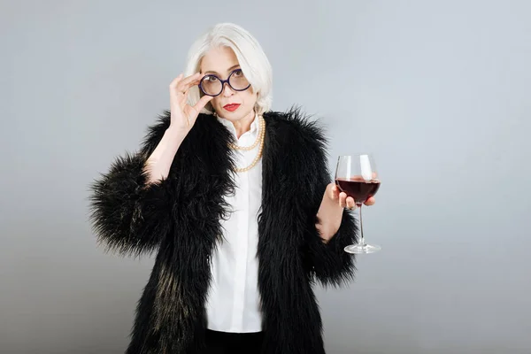 Serious senior beautiful woman holding wineglass. — Stock Photo, Image