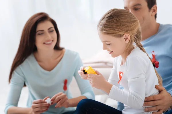 Feliz menina encantada segurando um brinquedo do conjunto meccano — Fotografia de Stock