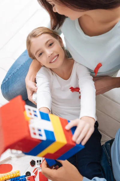 Cheerful pleasant girl showing the toy house — Stock Photo, Image