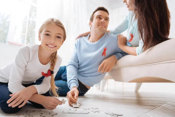 Glückliches nettes Mädchen, das mit einem Puzzle spielt — Stockfoto