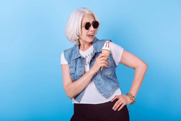 Content senior woman holding icecream and licking lips. — Stock Image Content senior woman holding icecream and licking lips. Stock Image