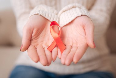 Close up of the AIDS symbol being in womans hands clipart