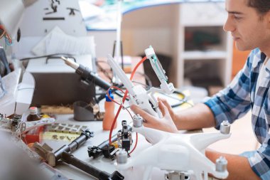 Genç adam birlikte tüm dron ayrıntıları dikkatle koyarak.