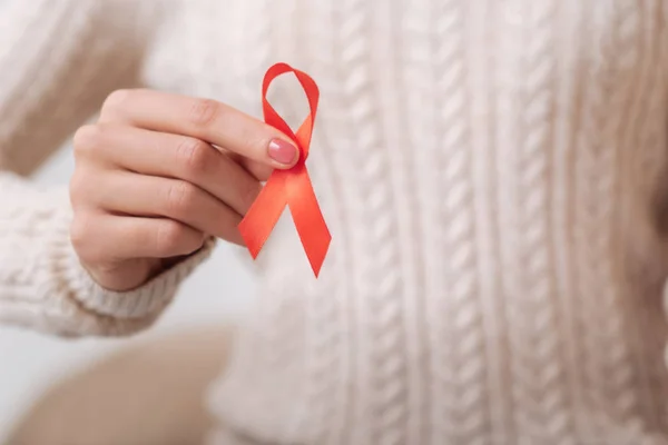 AIDS kırmızı kurdele bir kadın tarafından tutulan — Stok fotoğraf
