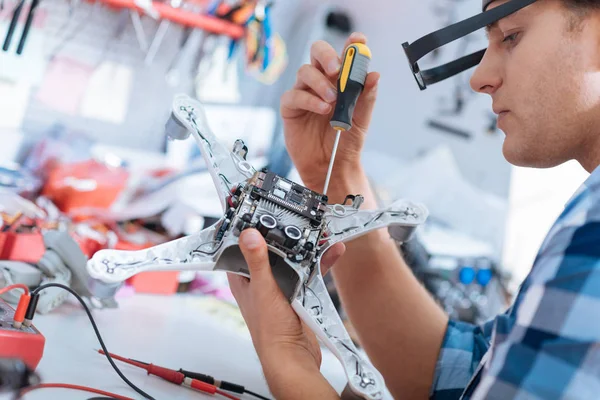 Schöner Mann repariert Drohne mit Schraubenzieher — Stockfoto