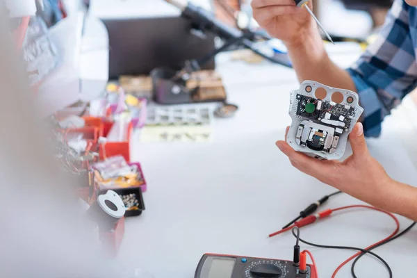 Primo piano del giovane che ripara il chip dei droni con un cacciavite — Foto Stock