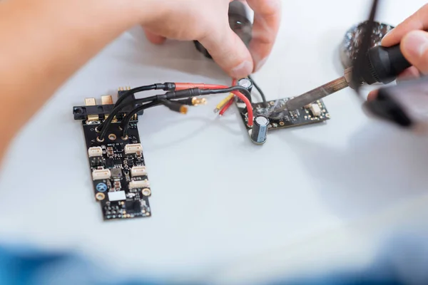 Nahaufnahme von Menschenhänden beim Löten zweier Drohnen-Chips — Stockfoto