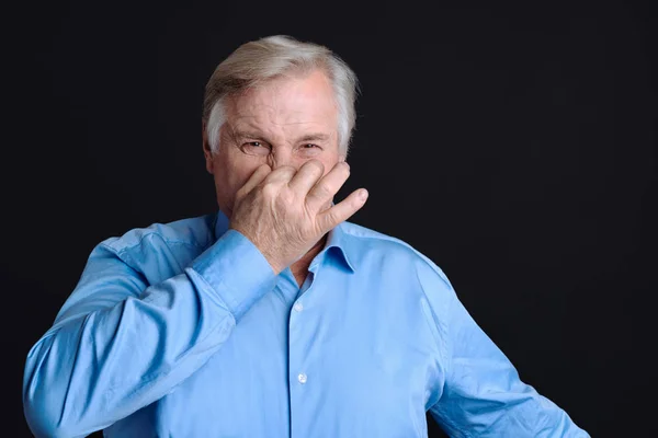El viejo se pellizca la nariz con el asco en la cara —  Fotos de Stock
