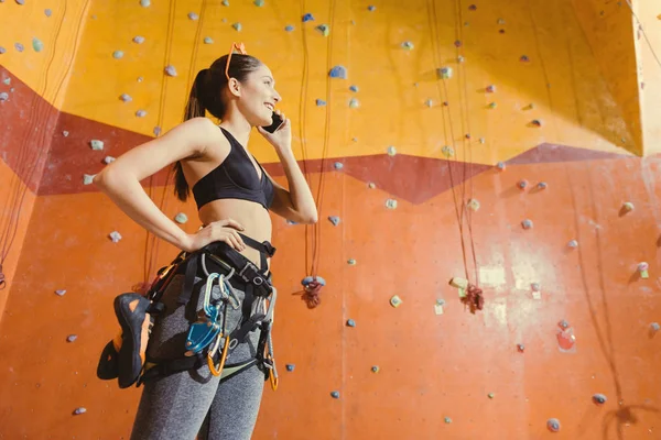 Donna gioiosa in piedi dietro la parete di arrampicata . — Foto Stock