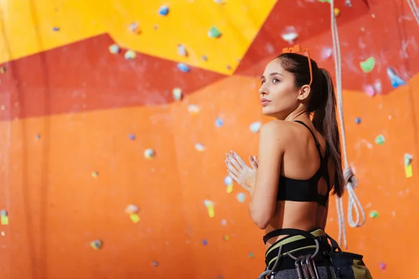 Konzentrierte Frau bereitet sich darauf vor, die Wand hochzuklettern — Stockfoto