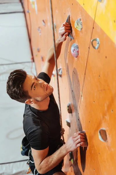 Junger Mann klettert in Turnhalle die Wand hoch — Stockfoto