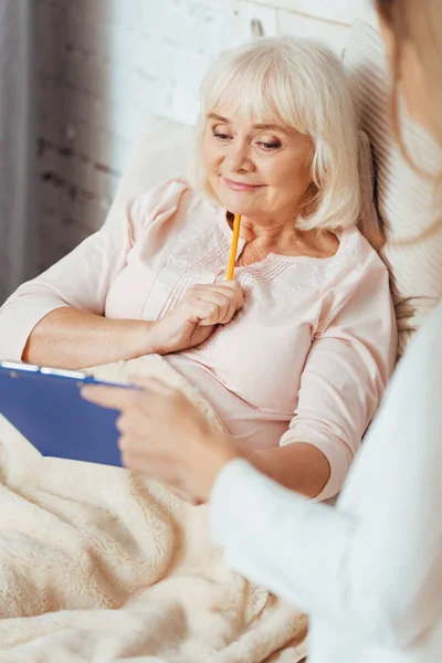 Amable médico profesional cuidando de una anciana — Foto de Stock