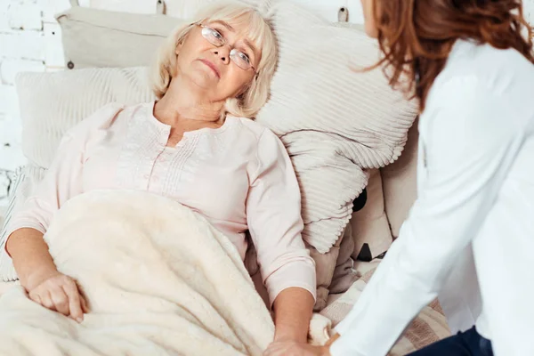 Malata donna anziana sdraiata a letto — Foto Stock