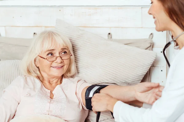 Positieve arts meten van de bloeddruk van haar patiënt — Stockfoto