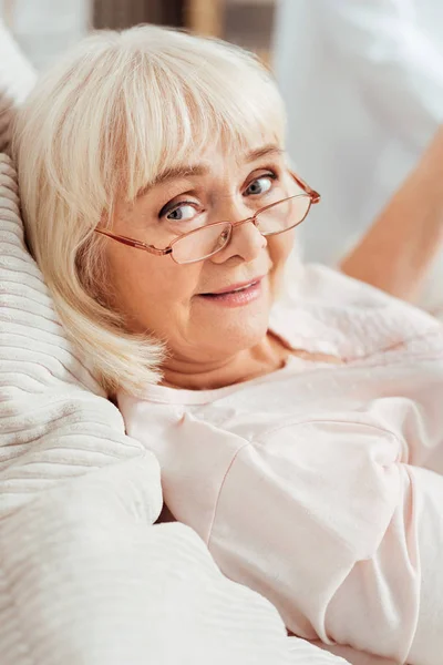 Agradable encantado anciana acostada en la cama — Foto de Stock