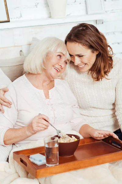 Positieve vrouw en haar lachende prachtige kleindochter omarmen — Stockfoto