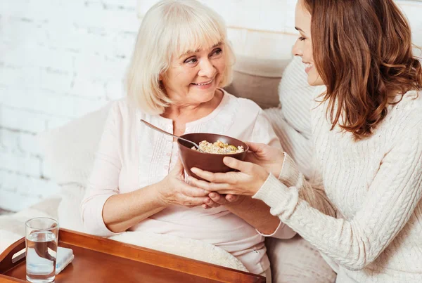 Приємна в захваті жінка розмовляє зі своєю молодою онучкою — стокове фото