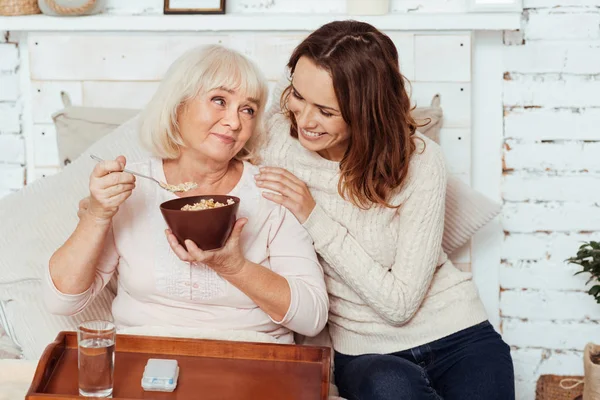 朝食を持っている肯定的な高齢者の女性. — ストック写真