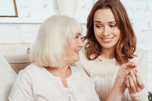 Positive elderly woman taking pill — Stock Photo, Image
