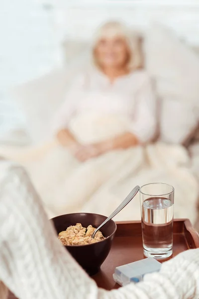 Angenehme Frau frühstückt auf dem Tablett — Stockfoto