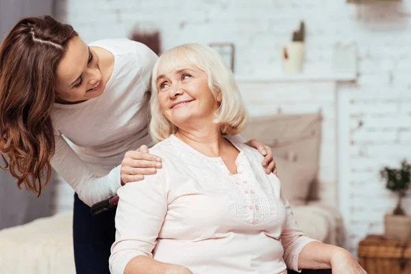 Mujer alegre cuidando de su abuela en silla de ruedas —  Fotos de Stock