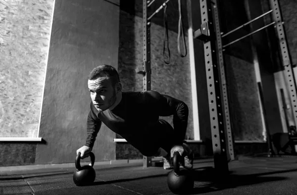 Well built brutal sportsman working out with kettlebells