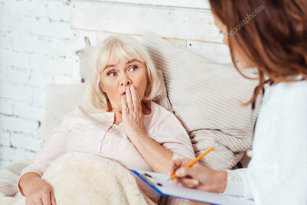 Professional doctor examining elderly woman