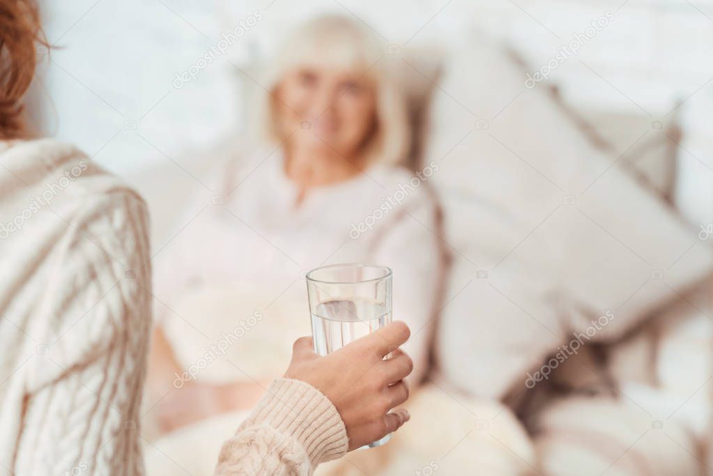 Pleasant young woman holding glass of water