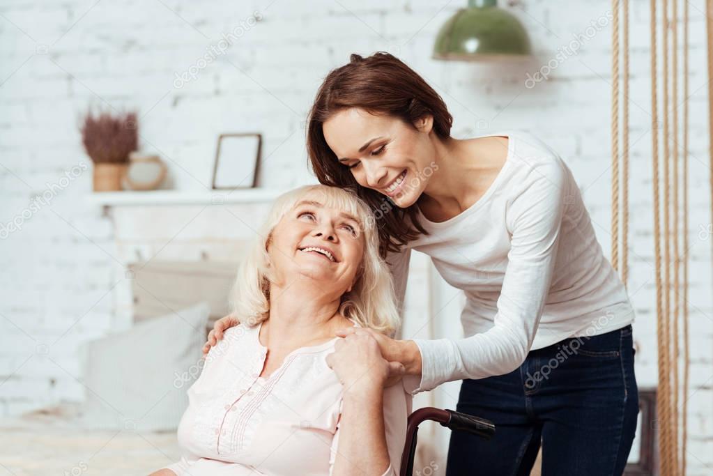 Positive woman taking care of her disabled grandmother