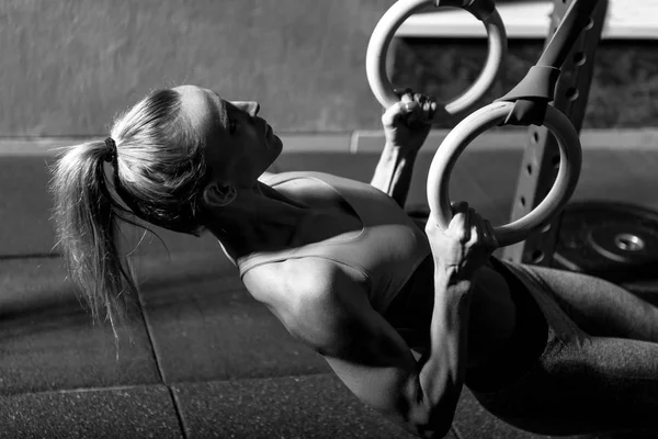 Gut gebaute attraktive Frau baut ihre Muskeln auf — Stockfoto