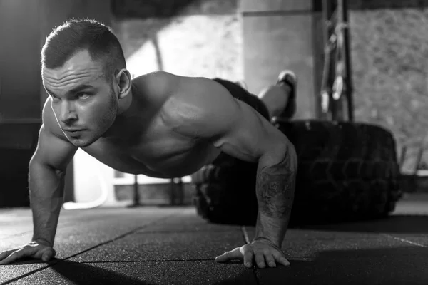 Koncentrerad ihållande bodybuilder göra push ups — Stockfoto