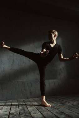 Yetenekli genç adam koyu ışıklı odaya gerçekleştirme