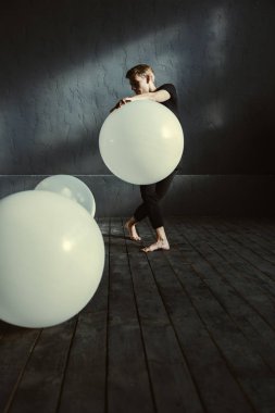 Genç dansçı karanlık duvara yakın performans konsantre