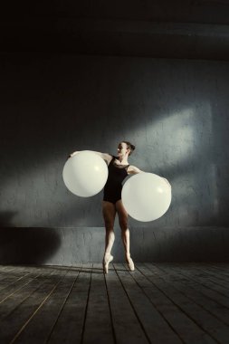 Beyaz topları kullanarak germe olumlu gülümseyen jimnastikçi