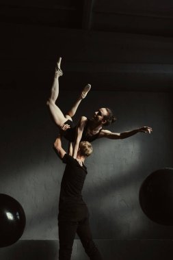 Yetenekli genç jimnastikçiler birlikte siyah renkli stüdyoda dans