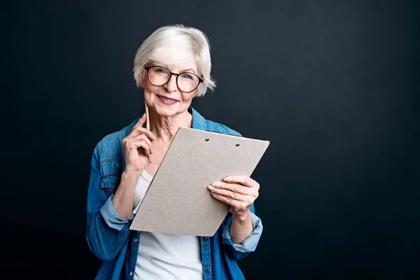 Fröhliche ältere Frau hält Ordner in der Hand — Stockfoto