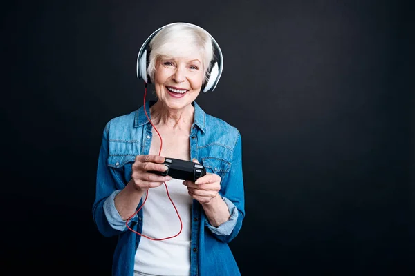 Mulher idosa positiva jogando videogames — Fotografia de Stock