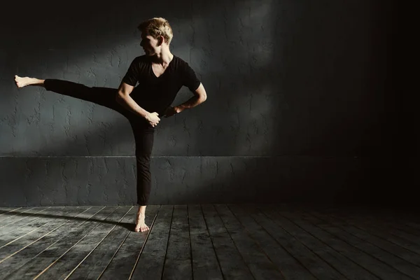 Képzett fiatal férfi táncolni a sötét megvilágított szobában — Stock Fotó