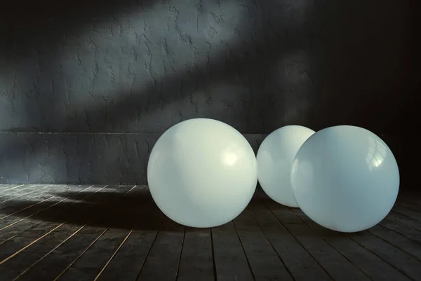 Drei große Ballons liegen im dunkel beleuchteten Raum — Stockfoto