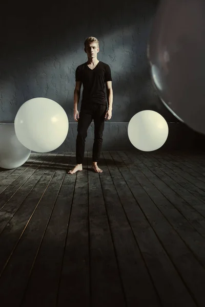 Junge Tänzerin steht im Studio voller weißer Luftballons — Stockfoto