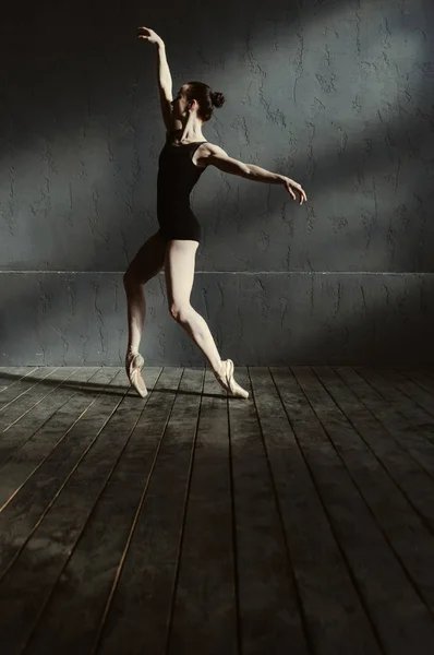 Joven bailarina actuando en la habitación con luz oscura — Foto de Stock